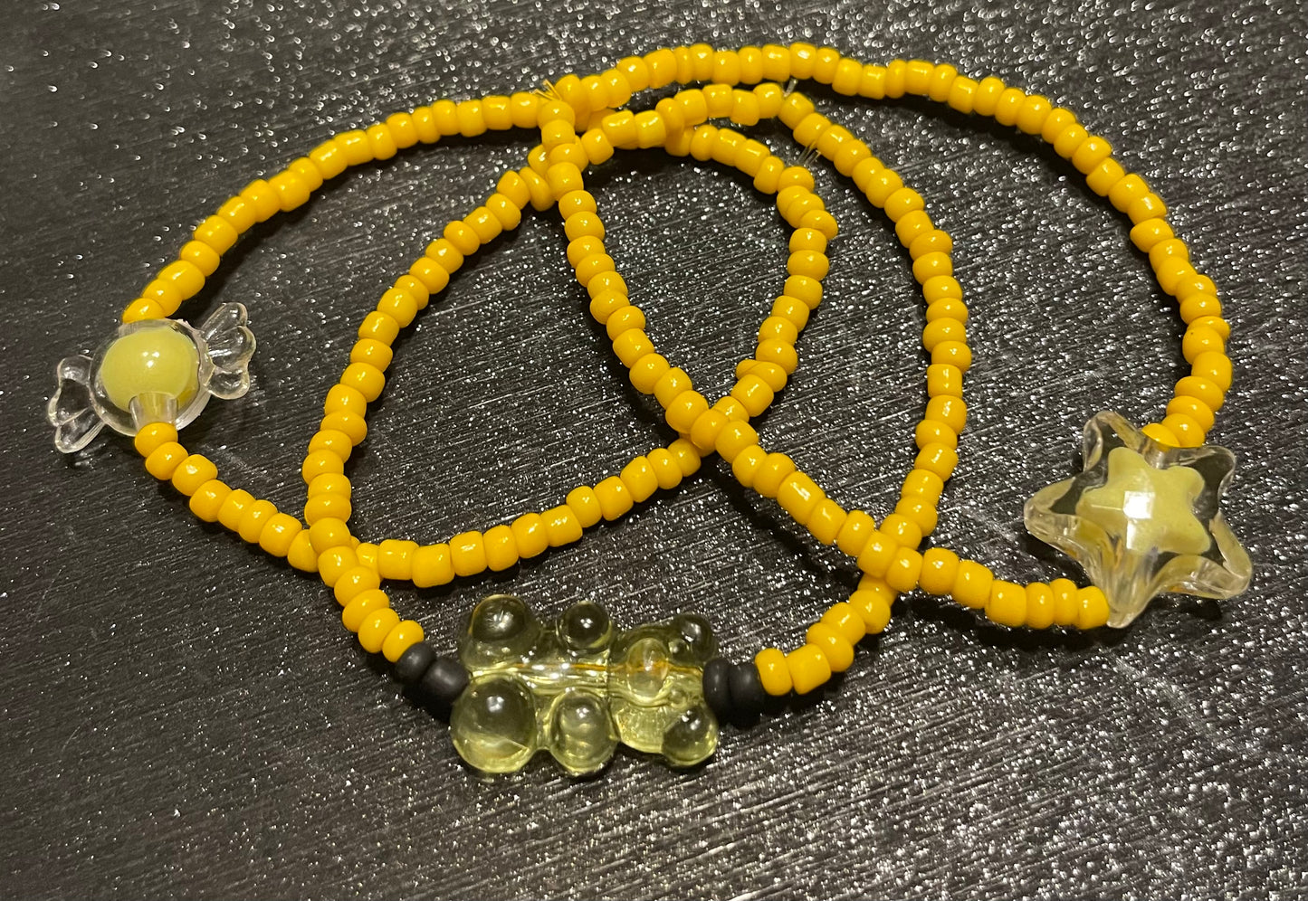 Yellow bracelets with gummy bear charm